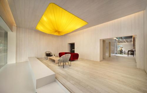 a living room with a red couch and a yellow light at Chengdu Chengshe Hotel - Wenjiang University Town Southwest Caida Branch in Chengdu