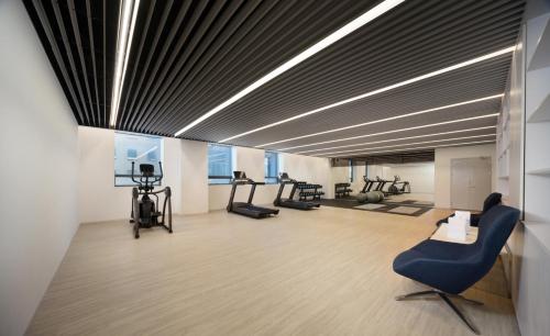 a room with a gym with treadmills and machines at Chengdu Chengshe Hotel - Wenjiang University Town Southwest Caida Branch in Chengdu