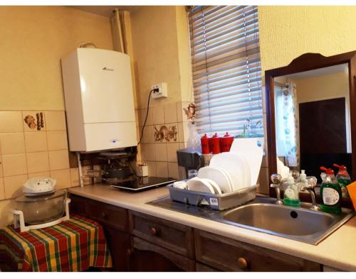 - un comptoir de cuisine avec un évier et un miroir dans l'établissement Private Annex, Little Flat, Private Entrance, à Nottingham