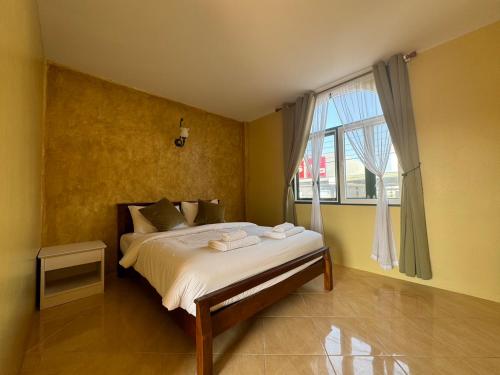 a bedroom with a bed and a large window at Venice Hotel Hua Hin in Hua Hin