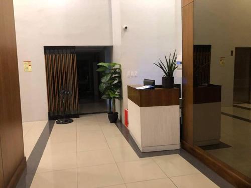 an office lobby with a reception desk and potted plants at 3 Beds Filinvest Alabang in Manila