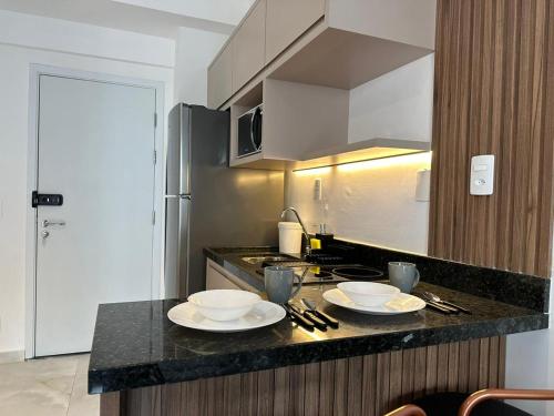 una cocina con 2 placas blancas en una encimera en Flat Encantador Allianz Park 607, en São Paulo