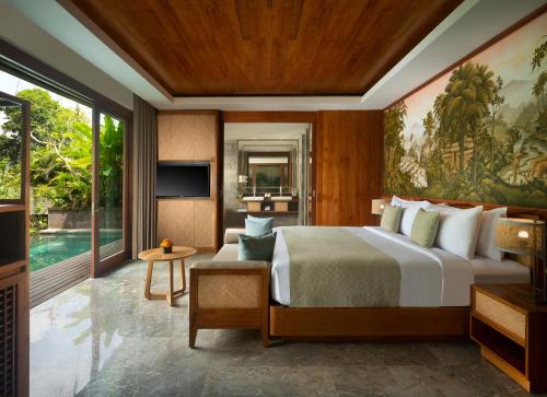 a bedroom with a large bed and a television at Suweta Villa Ubud in Ubud