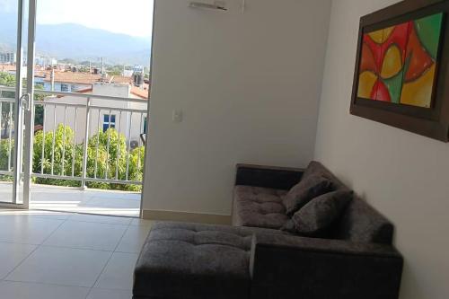 a living room with a couch and a large window at apartamento en santa marta in Nuevo Amanecer