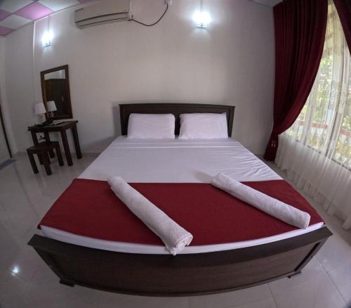 a bed in a bedroom with two pillows on it at Spice Village Hotel & Restaurant in Habarana