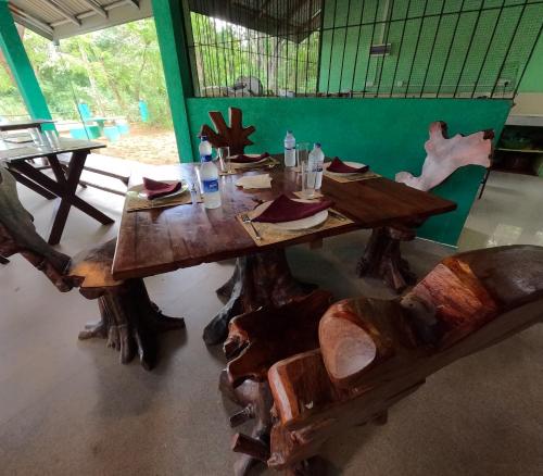 a wooden table and chairs in a room at Spice Village Hotel & Restaurant in Habarana