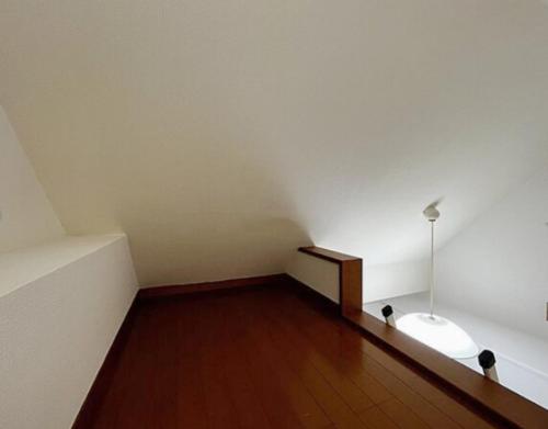 an empty room with a white wall and a wooden floor at Shinjuku sanchome Hana House in Tokyo