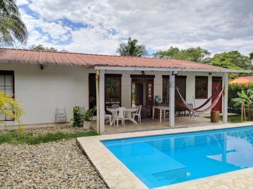 une villa avec une piscine et une maison dans l'établissement La Esthera Hospedaje Rural, à Carmen de Apicalá