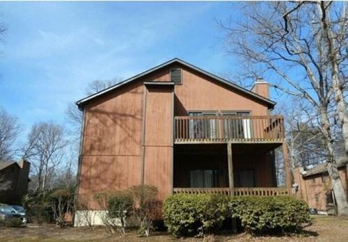 a house with a balcony on the side of it at Charming Condo Near WFU and Hospitals, Full Kitchen, Strong WiFi, In-Unit Laundry in Winston-Salem