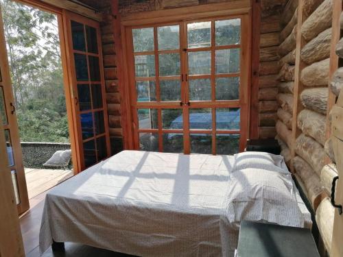 a bedroom with a bed in front of a window at Glamping Villa del Bosque in Santa Rosa de Cabal