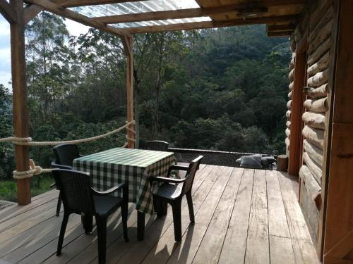 a wooden deck with a table and chairs on it at Glamping Villa del Bosque in Santa Rosa de Cabal
