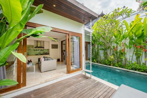 a house with a swimming pool and a living room at The Jimbaran Villa by Ini Vie Hospitality in Jimbaran