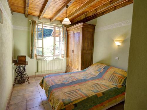 sypialnia z łóżkiem i dużym oknem w obiekcie Gîte et studio avec cheminée, terrasse, salle de jeux et nature préservée à La Versanne - FR-1-496-280 w mieście La Versanne
