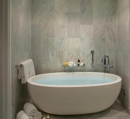 - dużą białą wannę w łazience z ręcznikami w obiekcie 5Hanza Tower 22nd Floor - BATHTUB -Sauna & Pool & SPA w Szczecinie