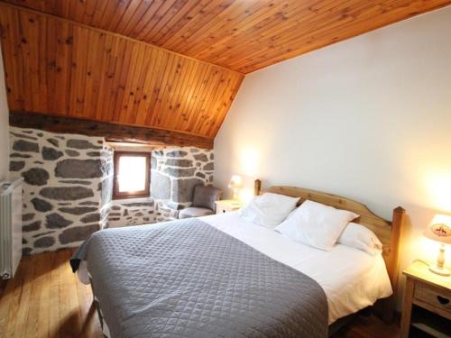a bedroom with a bed and a stone wall at Gîte Paulhac, 6 pièces, 12 personnes - FR-1-742-420 in Paulhac