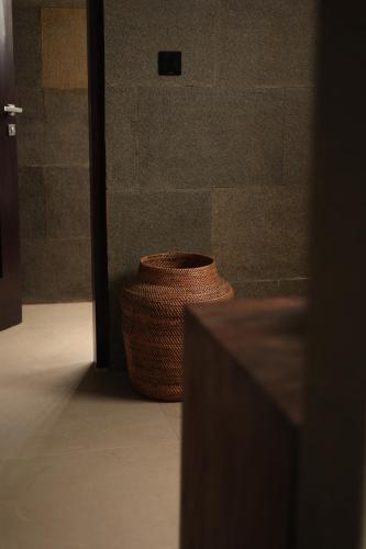 a brown vase sitting next to a wall at Menjaga Bay in Labuan Bajo