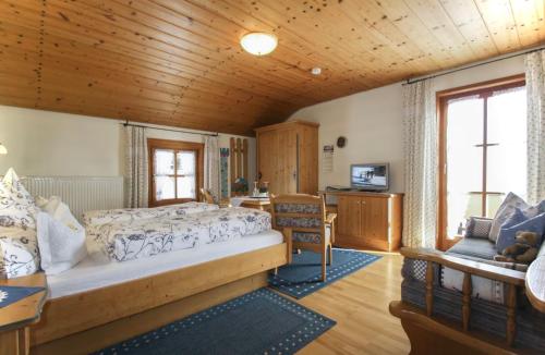 ein Schlafzimmer mit einem Bett und einem Schreibtisch in einem Zimmer in der Unterkunft Gästehaus Herbstbauernhof in Siegsdorf