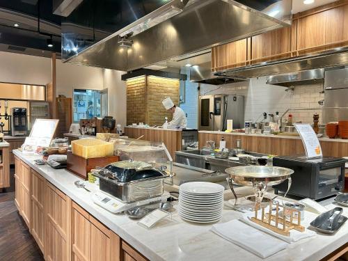 a kitchen with a chef standing in a kitchen at Garden Hotel Shizuoka in Shizuoka