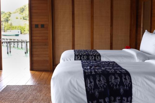 a bedroom with two beds with white sheets at Menjaga Bay in Labuan Bajo