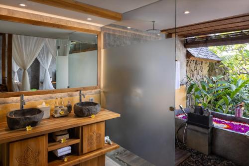 2 lavabos en un baño con un espejo grande en Wana Bucu Villas by Pramana Villas en Ubud