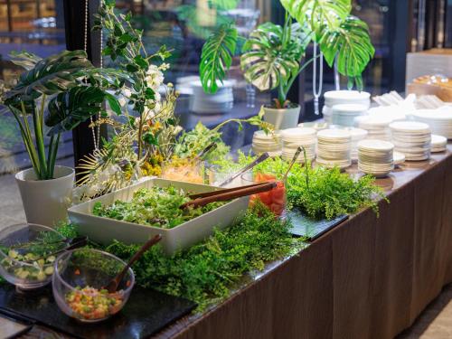 a buffet with plants and dishes on a table at THE BLOSSOM KUMAMOTO in Kumamoto