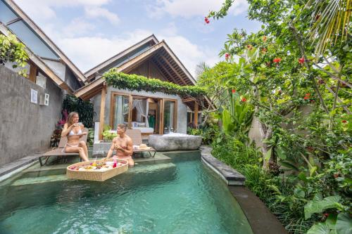 two women sitting in a pool in a house at Wana Bucu Villas by GenuineHost in Ubud