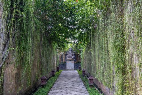 a walkway with a statue in the middle at Wana Bucu Villas by GenuineHost in Ubud
