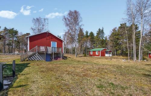 a red barn and a red house in a field at Gorgeous Home In Jämjö With Kitchen in JÃ¤mjÃ¶