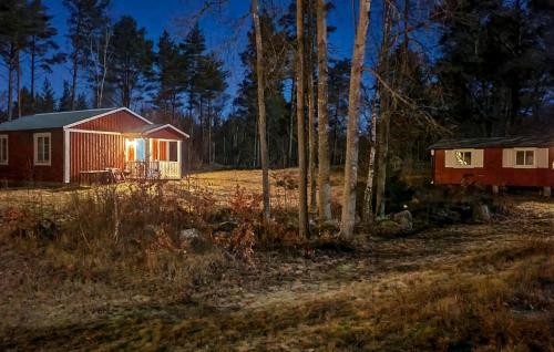 a cabin in the woods at night with the lights on at Gorgeous Home In Jämjö With Kitchen in JÃ¤mjÃ¶
