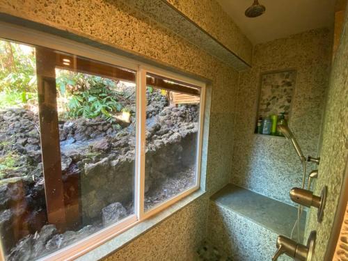 a bathroom with a window and a rock wall at Private and Quiet Guest Apt in Hawaii Cloud Forest in Kailua-Kona
