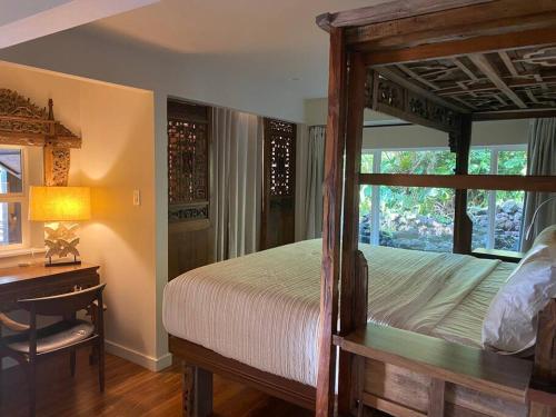 a bedroom with a wooden bed and a desk and a bed sidx sidx sidx at Private and Quiet Guest Apt in Hawaii Cloud Forest in Kailua-Kona