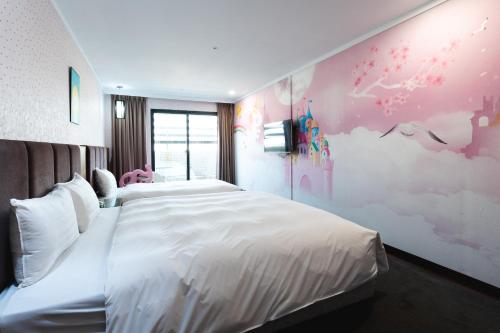 a bedroom with a white bed and a pink wall at Shianghu Boutique Hotel in Chiayi City