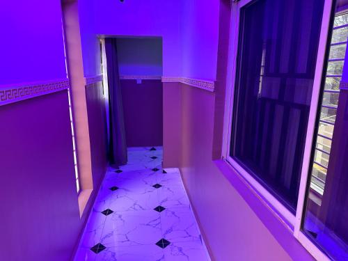 Habitación púrpura con pasillo y ventana en Crest Suite and Lifestyle en Owerri