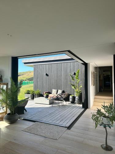 a living room with a couch and a patio at Ocean + Country - Wainui Beach in Gisborne