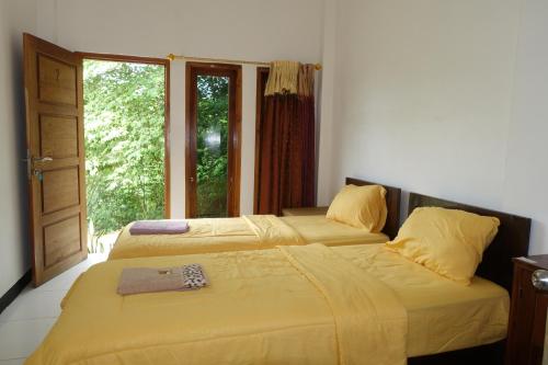 two beds sitting next to each other in a bedroom at Tarsan Homestay in Labuan Bajo