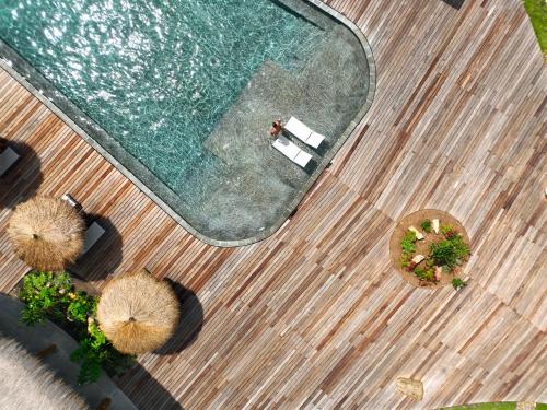 an overhead view of a swimming pool with tables and chairs at Menjaga Bay in Labuan Bajo
