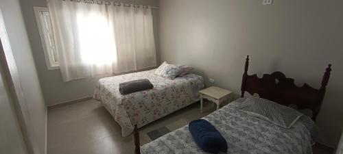 ein kleines Schlafzimmer mit 2 Betten und einem Fenster in der Unterkunft Hospedagem Sol Nascente - Pé na Areia in Arroio do Silva