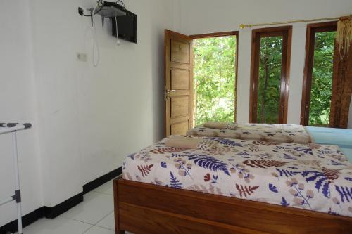 a bedroom with a bed and a window at Tarsan Homestay in Labuan Bajo