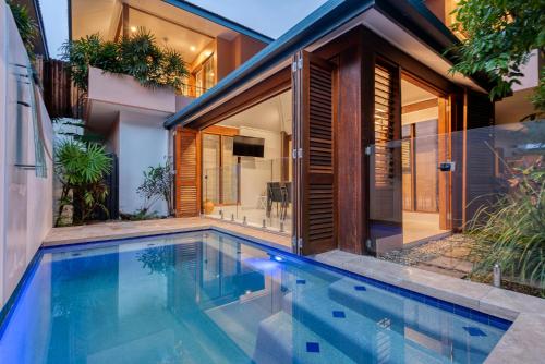 a swimming pool in front of a house at Villa 3 @ Chez Willow, 2 mins to Four Mile Beach in Port Douglas