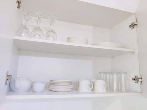 a white shelf with plates and dishes on it at Guesthouse in Suva in Suva