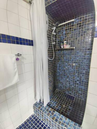 a bathroom with a shower with blue tiles at Guesthouse in Suva in Suva