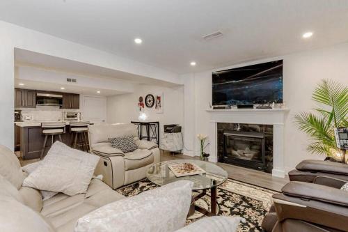 a living room with white furniture and a fireplace at Luxury Basement Apartment in Oakville Monthly stays only in Oakville