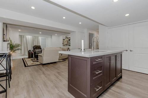 a kitchen with a sink and a living room at Luxury Basement Apartment in Oakville in Oakville
