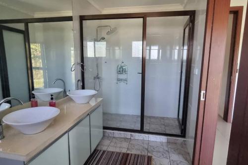 a bathroom with two sinks and a shower at Large 4 bedroom villa with Pool in Sonaisali Nadi in Nadi