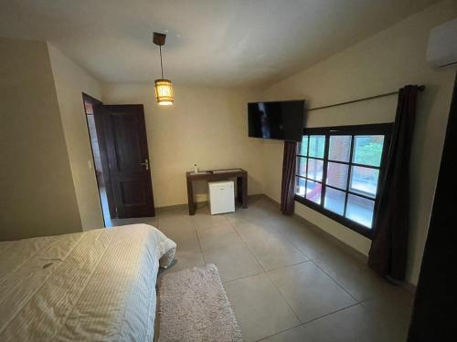 盧米亞爾的住宿－Pousada Som de Lumiar，一间卧室配有一张床和一台平面电视