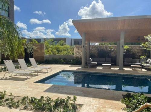 uma piscina com cadeiras e um pavilhão em Condominio de lujo Coral en Canamar Cap Cana em Punta Cana