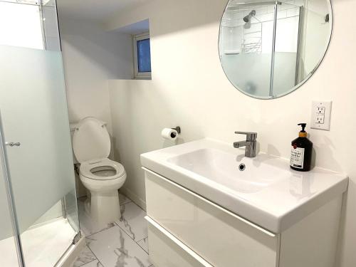 a bathroom with a sink and a toilet and a mirror at Downtown Private Suite in Toronto