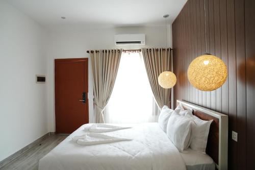 a bedroom with a white bed with a window at One Beach Resort By EHM in Koh Rong Sanloem