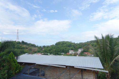a building with a metal roof on top of a hill at Tarsan Homestay in Labuan Bajo