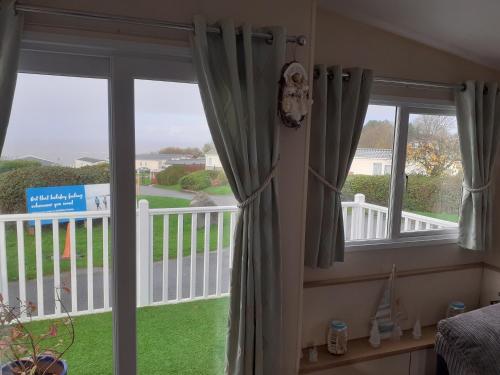 a bedroom with a window with a view of a yard at 32 powys Quay west caravan park newquay ceredigion in New Quay